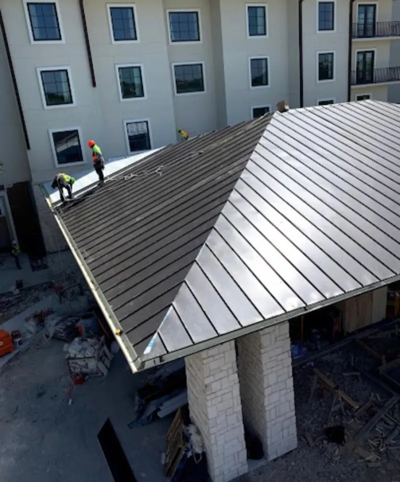 Crew installing standing seam metal roof panels on a commercial project in DeLand